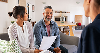 smiling young couple at home talking to advisor